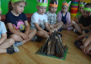 Dzieci odpoczywają przy modelu ogniska
